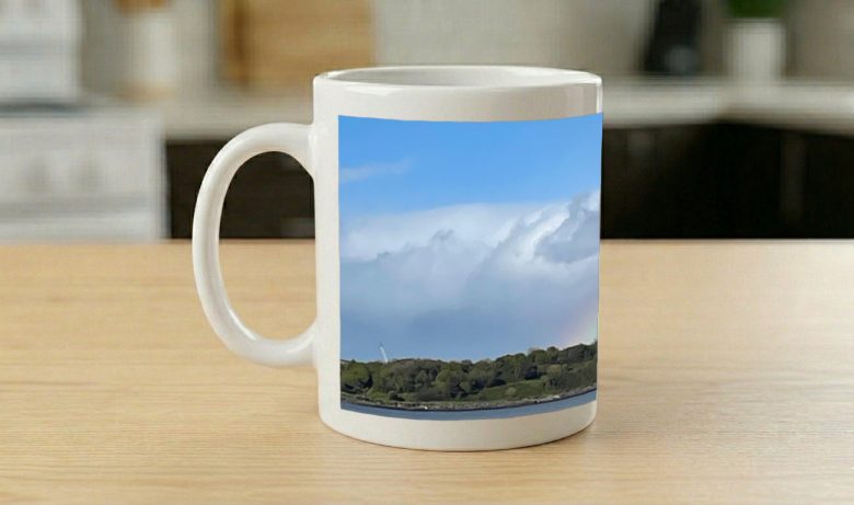 Mug printed with a panorama of the Poolbeg chimneys across water, a rainbow over the shoreline